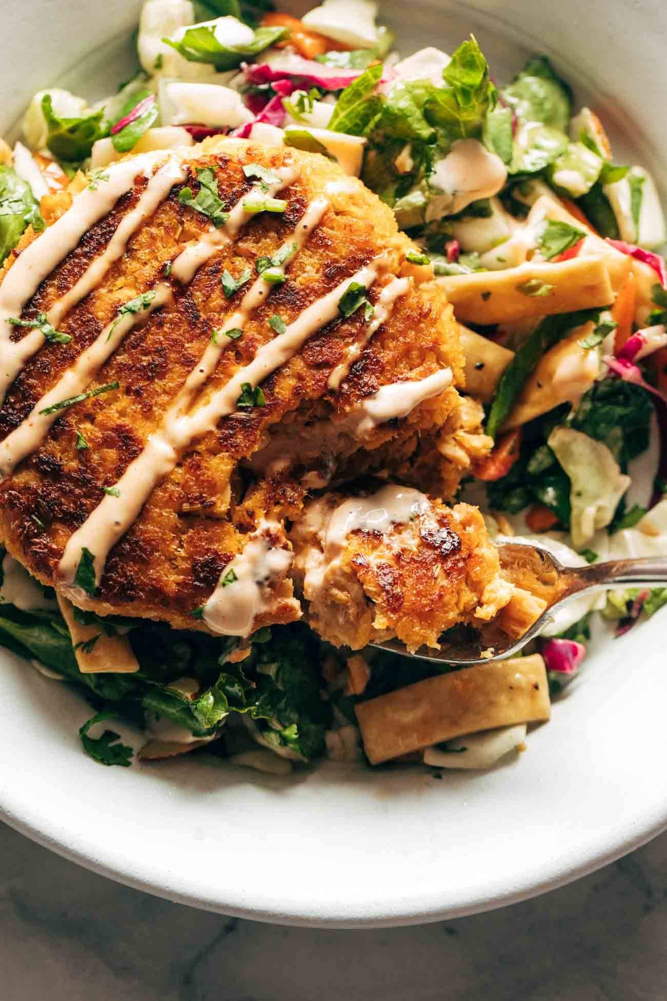 Spicy salmon burger with salad mix.